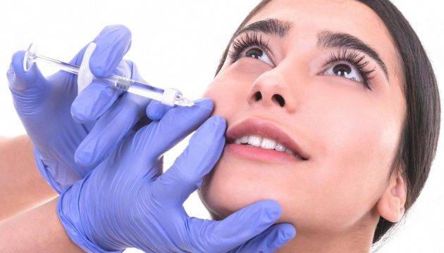 Cosmetologist performing a personalised injection treatment on a young woman in a UAE clinic