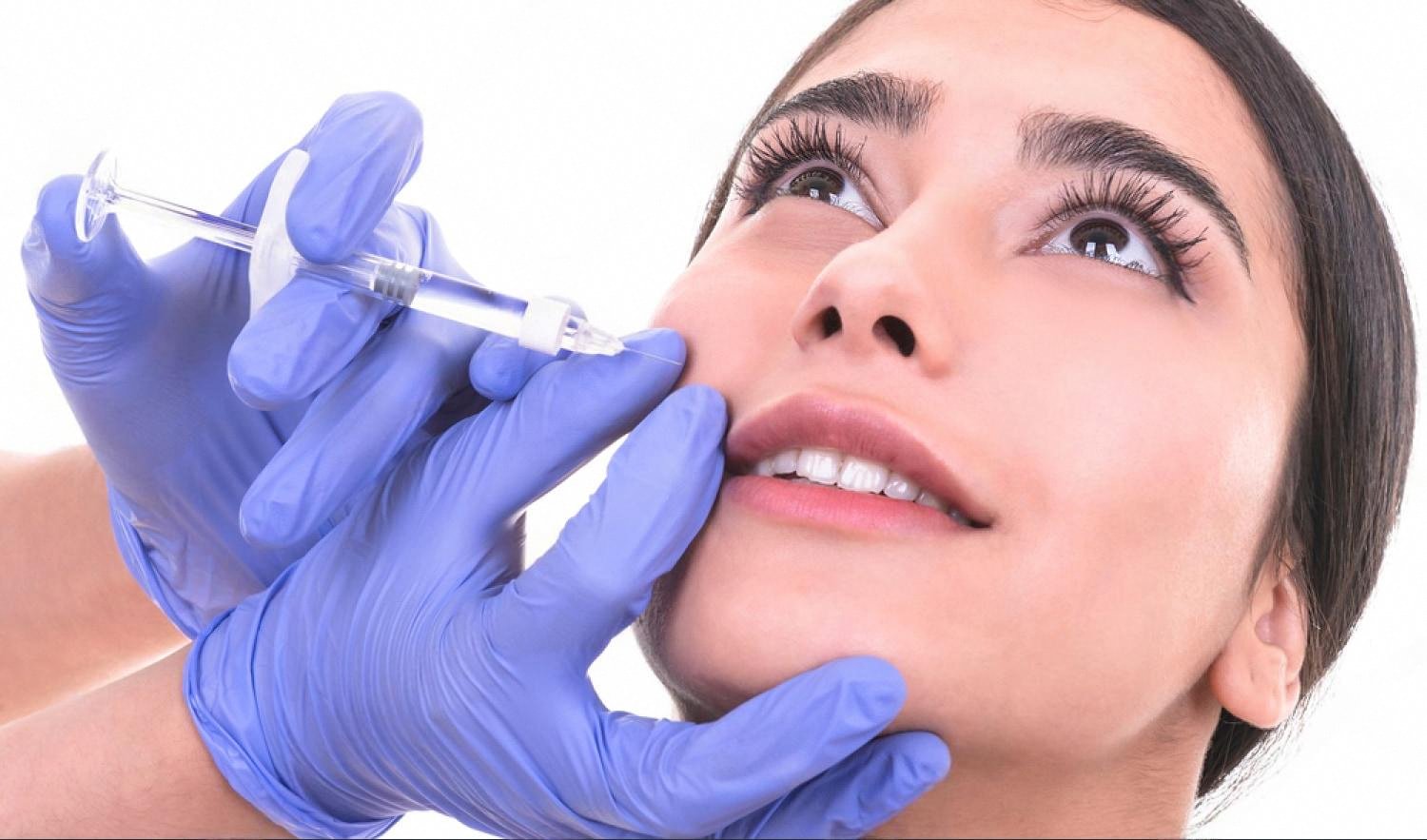 Cosmetologist performing a personalised injection treatment on a young woman in a UAE clinic